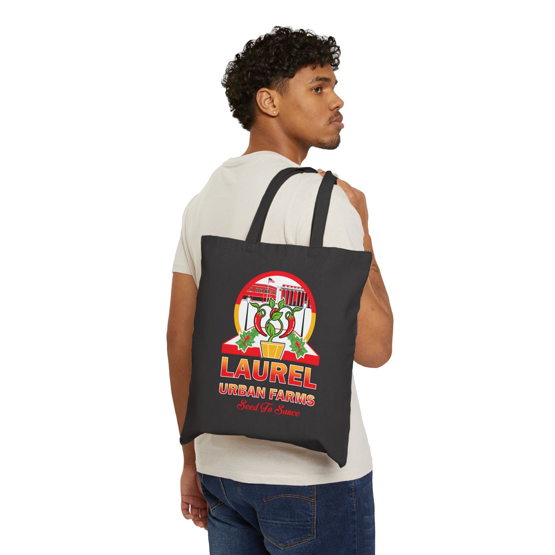 Person showcasing the Laurel Urban Farms orange, yellow, red and white logo. Double-sided canvas tote in black